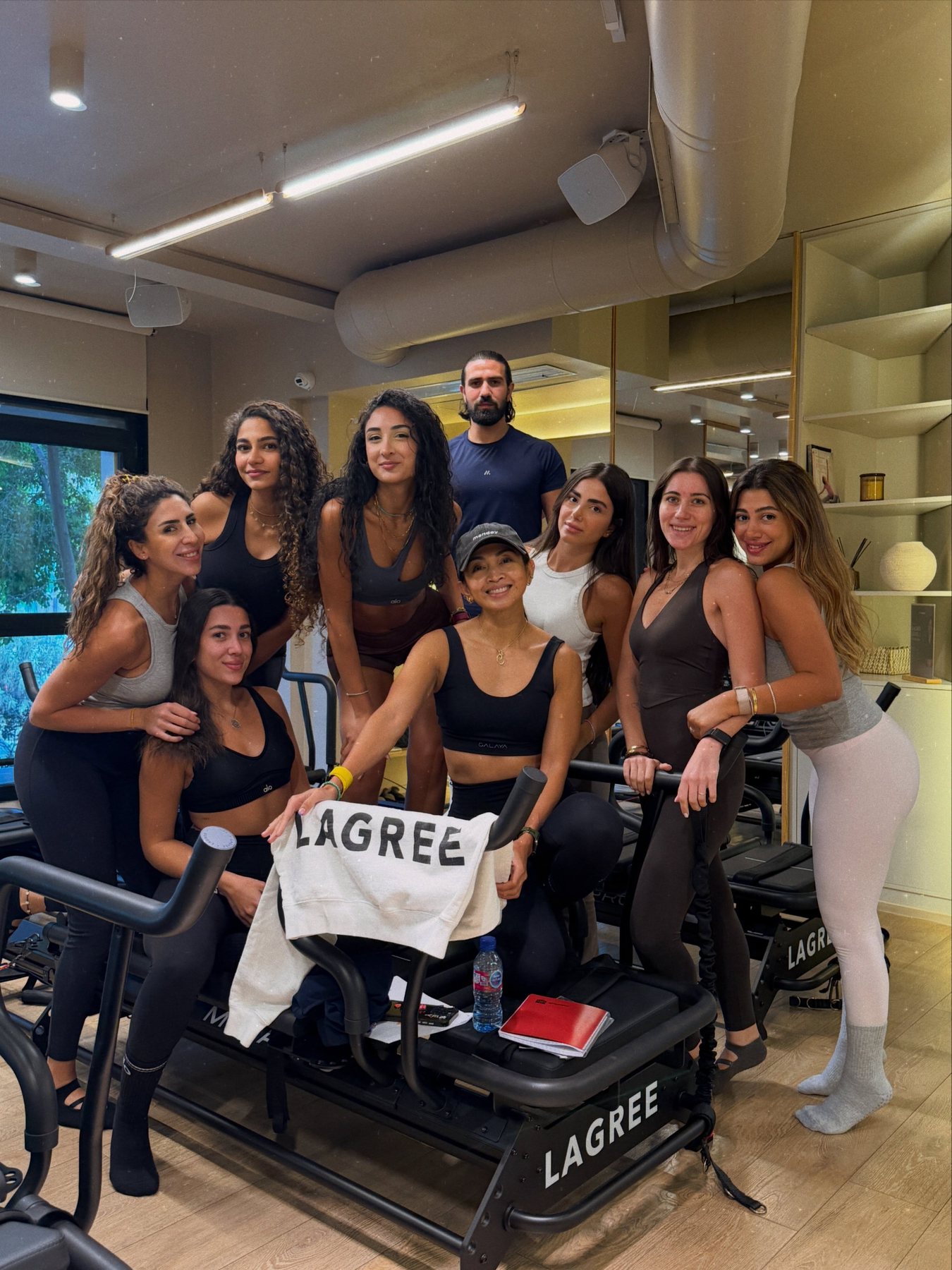 Ciarra with her smiling Lagree trainees gathered around a Megaformer in Beirut